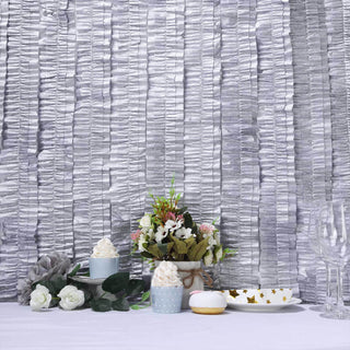 Decorative table setting with cupcakes, flowers, and glassware.