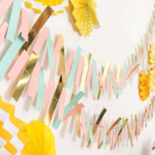 Colorful paper garland decoration in pastel pink, mint, and gold tones.