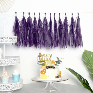Purple tassel garland decoration for birthday parties with cake and dessert setup.
