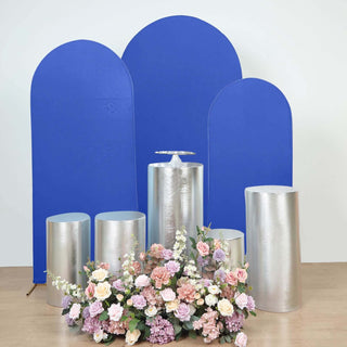 Decorative silver pedestals and blue backdrops with floral arrangement.