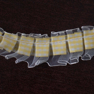 Yellow checkered ribbon with ruffled edges on a dark background.