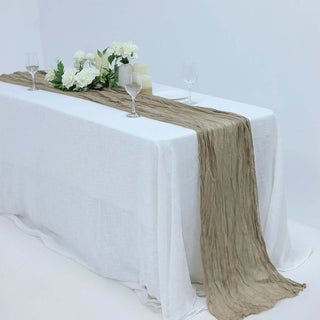 Elegant beige table runner on a white table with floral decor and glassware.