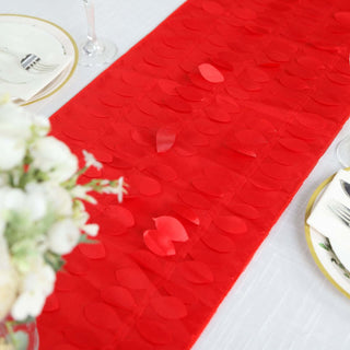 Red heart-shaped table runner on a dining table with floral centerpiece.