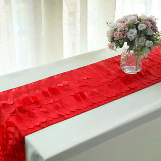 Red decorative table runner with textured petals, styled with a floral vase.