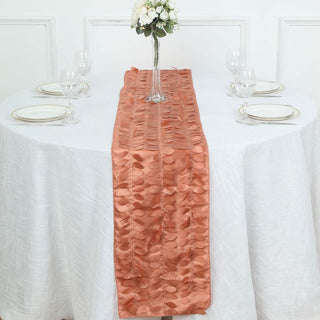 Peach satin table runner on a white tablecloth with glassware and plates.
