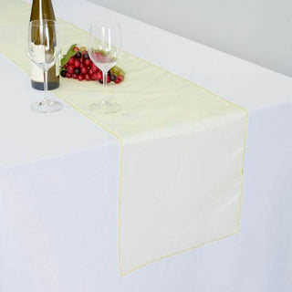 Table setting with wine, glasses, and fruit on a white tablecloth.
