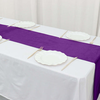 Purple table runner with white scalloped plates and chopsticks set on a table.