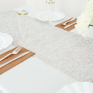 Elegant white lace table runner with gold accents on a dining table.