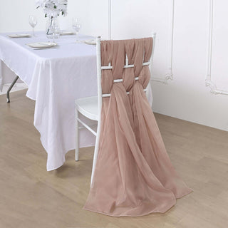 Elegant blush chair sash draped on a white chair at a dining table setting.