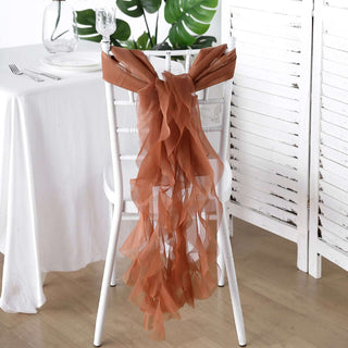 Brown chiffon chair sash draped on a white chair at a table setting.