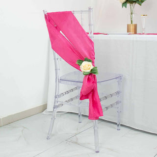 Clear acrylic chair with pink sash and flower decoration.