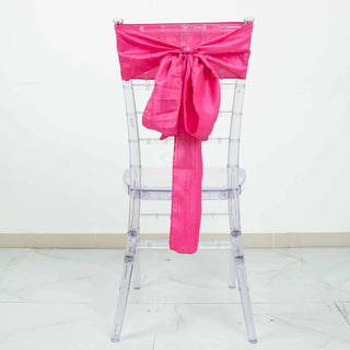 Clear acrylic chair with a vibrant pink satin bow on the back.