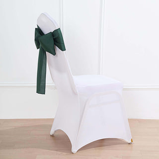 White chair cover with a green bow, perfect for events and celebrations.