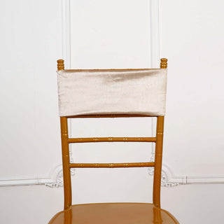 Gold chiavari chair with a satin backrest on a plain background