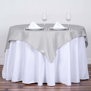 Add Elegance to Your Event with the 54x54 Silver Square Polyester Table Overlay Add Elegance to Your Event with the 54x54 Silver Square Polyester Table Overlay