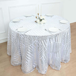 Elegant round table with a silver sequin tablecloth and floral centerpiece.