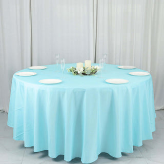 Round table set with light blue tablecloth and decorative candles.