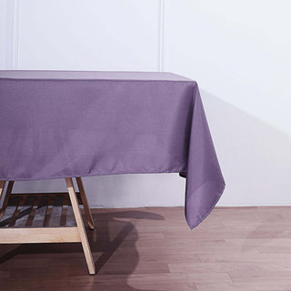 Purple tablecloth draped over a wooden table in a minimalistic setting.