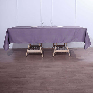 Purple tablecloth on a wooden table set with glasses.