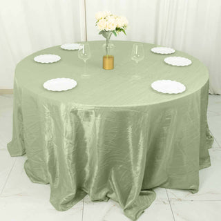 Round olive green tablecloth with plates and glasses set for dining.