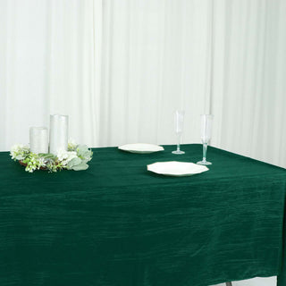 Elegant green tablecloth set with decorative candles and plates.