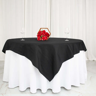 Elegant black tablecloth draped over a white table with roses and wine glasses.