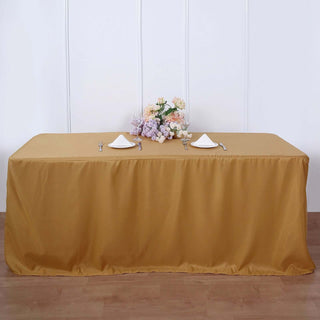Elegant gold tablecloth draped over a table with floral centerpiece and table settings.