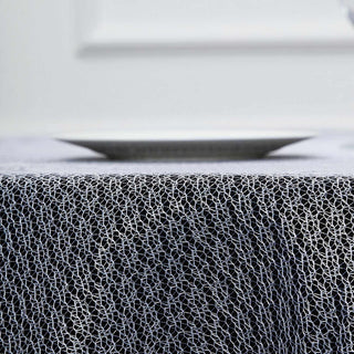 Black and white textured tablecloth with a plate on top.