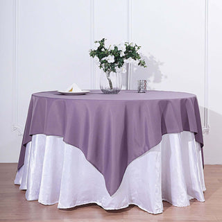 Purple tablecloth draped over a round table with white underneath.