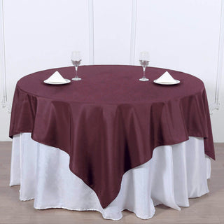 Add Elegance to Your Event with the Burgundy Square Seamless Polyester Table Overlay