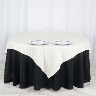 Add Elegance to Your Event with the 70x70 Ivory Square Polyester Table Overlay Add Elegance to Your Event with the 70x70 Ivory Square Polyester Table Overlay
