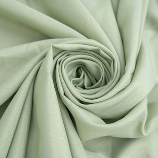 Light green fabric rolled in a spiral, showcasing its smooth texture.