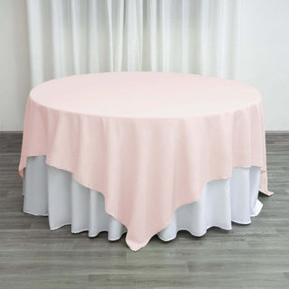 Round pink tablecloth draped over a white table.