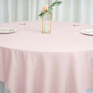 Round pink tablecloth on a dining table with elegant decor.
