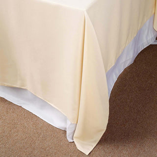 Beige tablecloth draping elegantly over a white table covering.