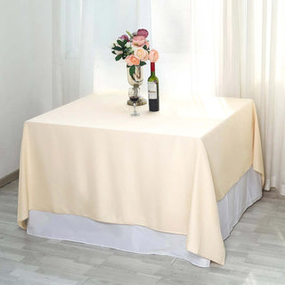 Elegant beige tablecloth draped over a table with flowers and wine.