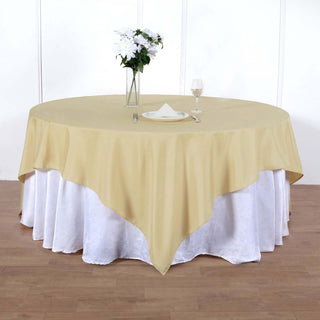 Round table with beige tablecloth and white skirt, set for dining.