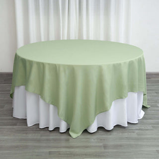 Round green tablecloth draped elegantly over a white table.