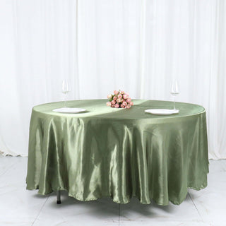 Elegant green tablecloth with floral centerpiece and wine glasses.