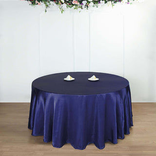 Round navy tablecloth draped elegantly over a table with decorative plates.