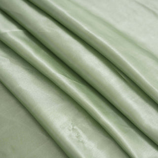 Soft green silk fabric draped in gentle folds.