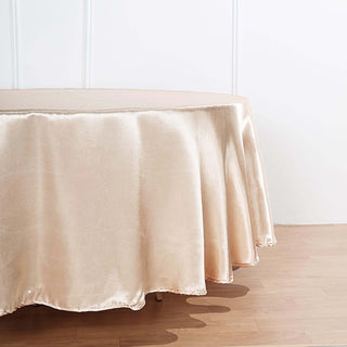 Elegant satin tablecloth in soft gold hue draping over a table edge.