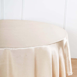 Round beige tablecloth on a wooden surface.