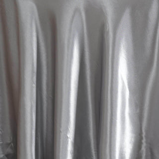 Silver satin fabric with soft drapes and subtle sheen.