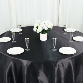 Elegant dining table setup with white plates, glasses, and floral centerpiece.