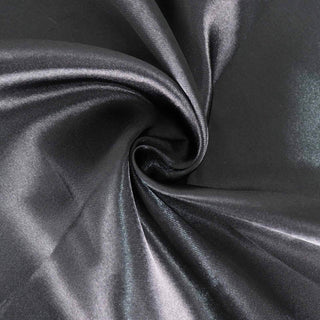 Black satin fabric with a smooth, shiny texture in a swirling pattern.