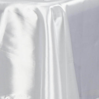White satin fabric draped elegantly on a surface.
