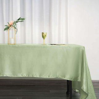 Elegant green tablecloth draped on a table with decor and glassware.
