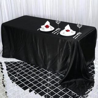 Black tablecloth draping elegantly over a dining table set for two.