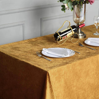 Elegant gold tablecloth with wine and dinnerware set for a sophisticated dining experience.